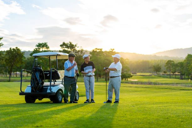 Group of Asian people businessman and senior CEO enjoy outdoor sport lifestyle golfing together at golf country club. Healthy men golfer shaking hand after finish talking business project and game on golf course