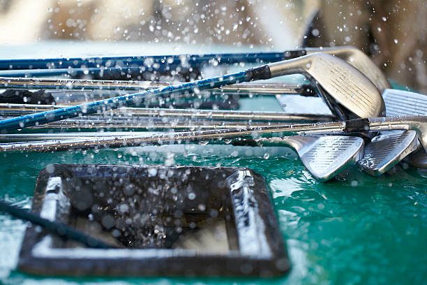 Golf clubs at the cleaning station with water drops